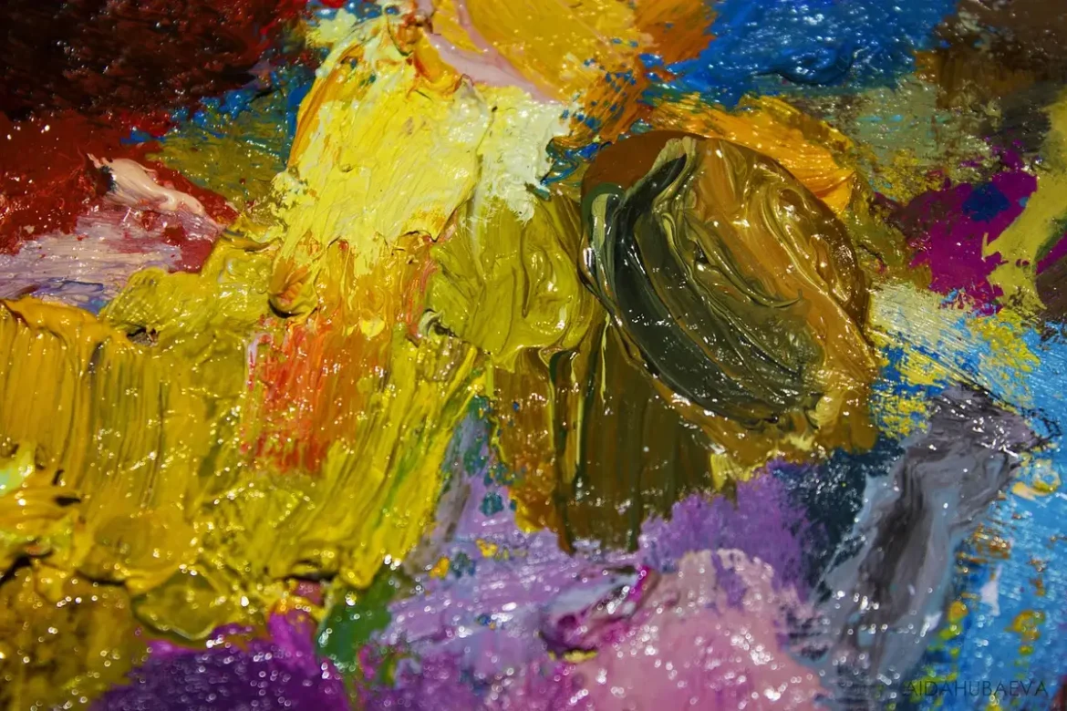 Mains anonymes mélangeant des peintures sur une palette près d'une fenêtre en plein jour